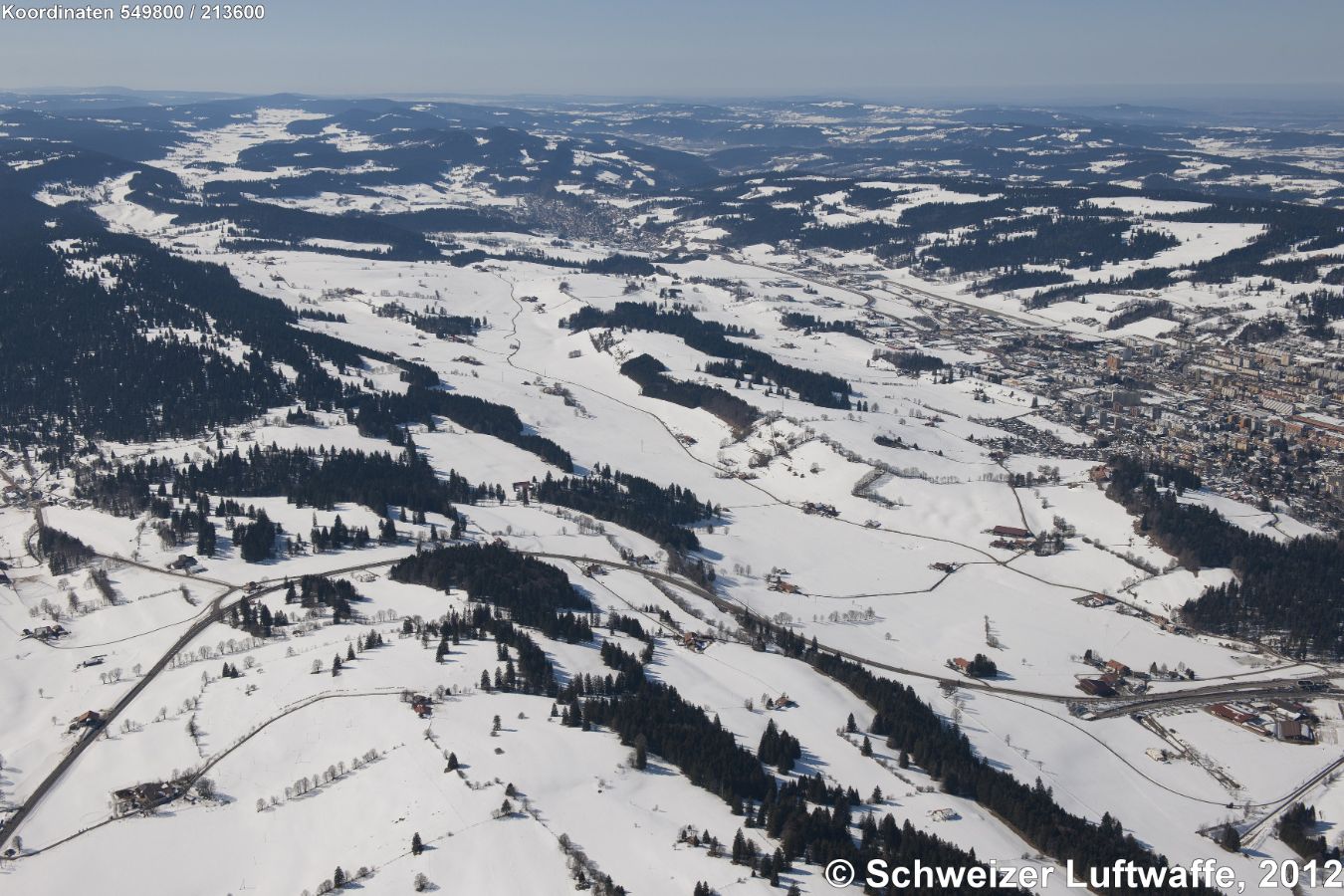 La Chaux-de-Fonds (rechts im Bild) und Le Locle (Bildmitte hinten). Vorne rechts: am Bildrand Bahntunnel ' Tunnel des Loges', und Strassentunnel 